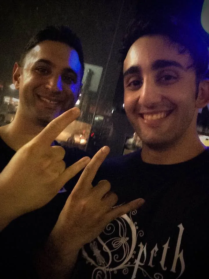 Two friends grinning at an Opeth gig.