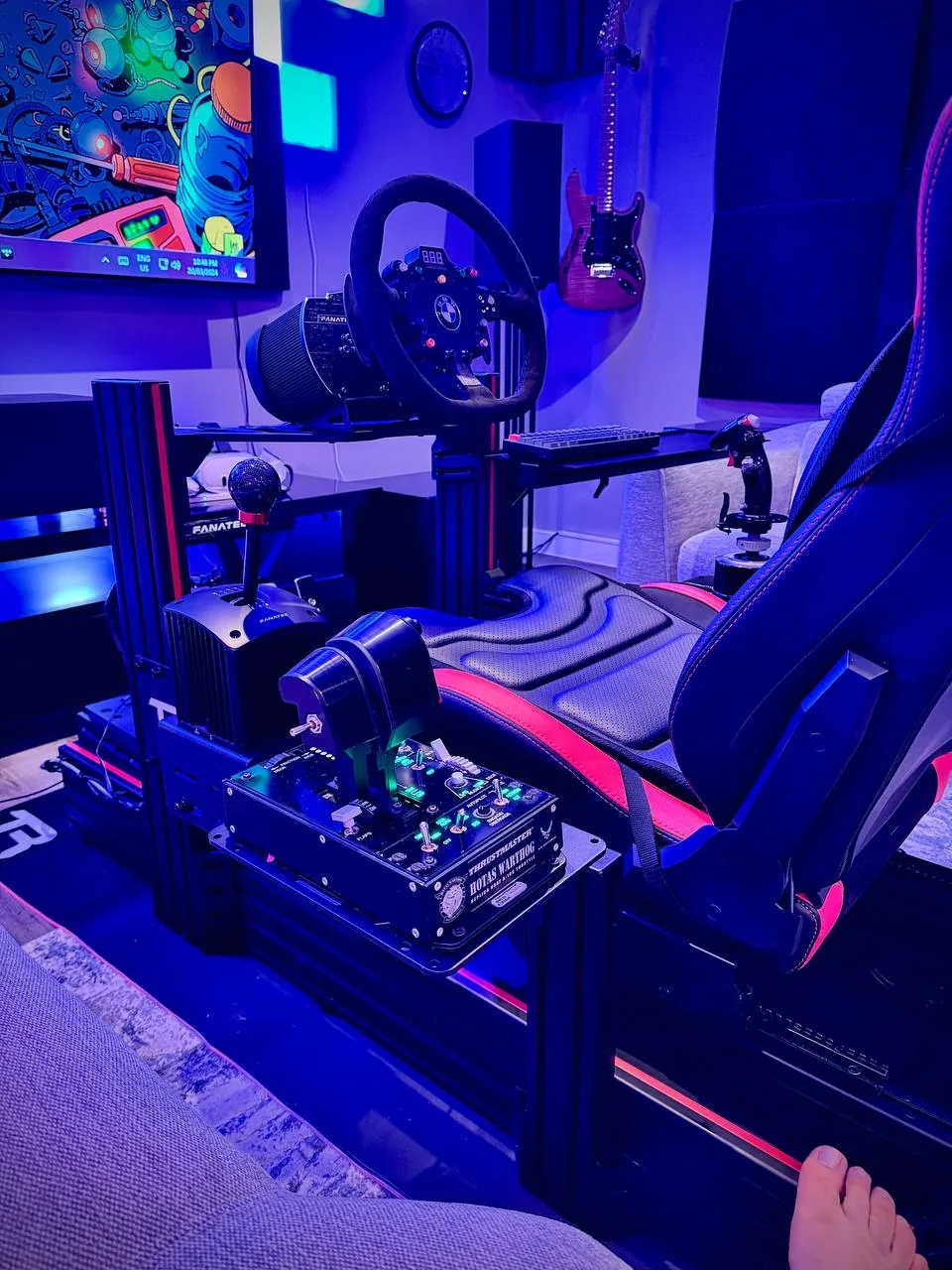 A sim-racing rig with wheel, shifter and HOTAS in blue light.