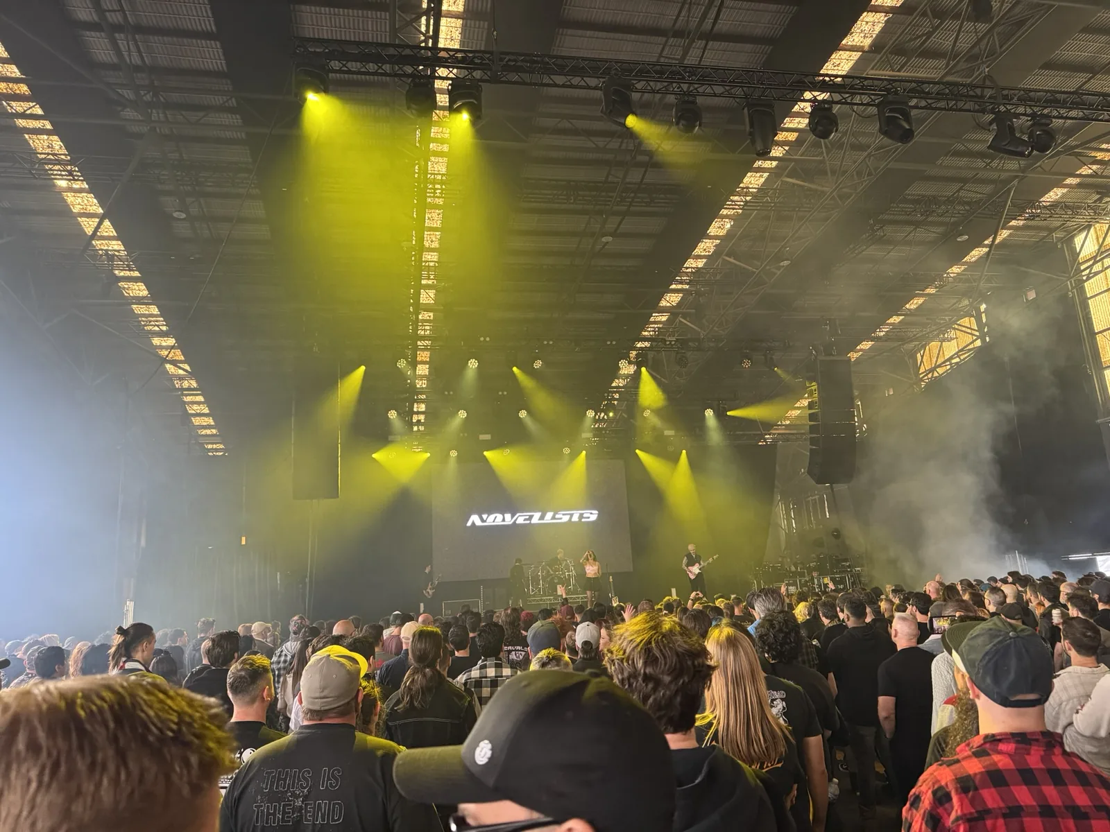 A festival hangar washed in yellow stage light.