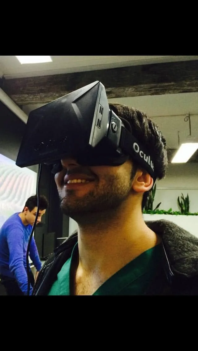 Smiling in an Oculus Rift headset, scrubs visible.