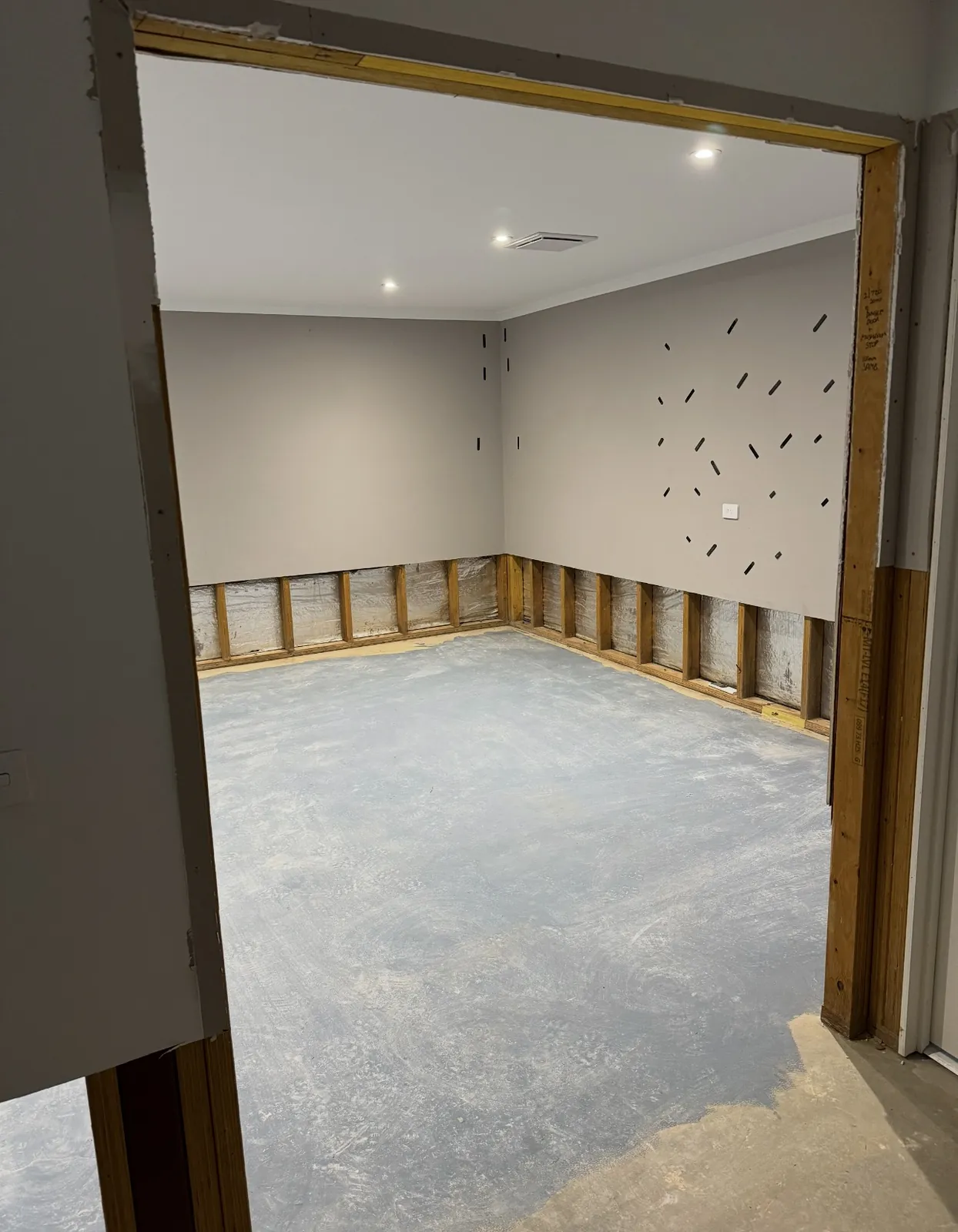 The emptied room after strip-out, bare studs showing.