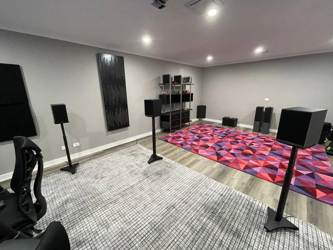 The previous listening room with acoustic panels, speaker stands and a geometric rug.