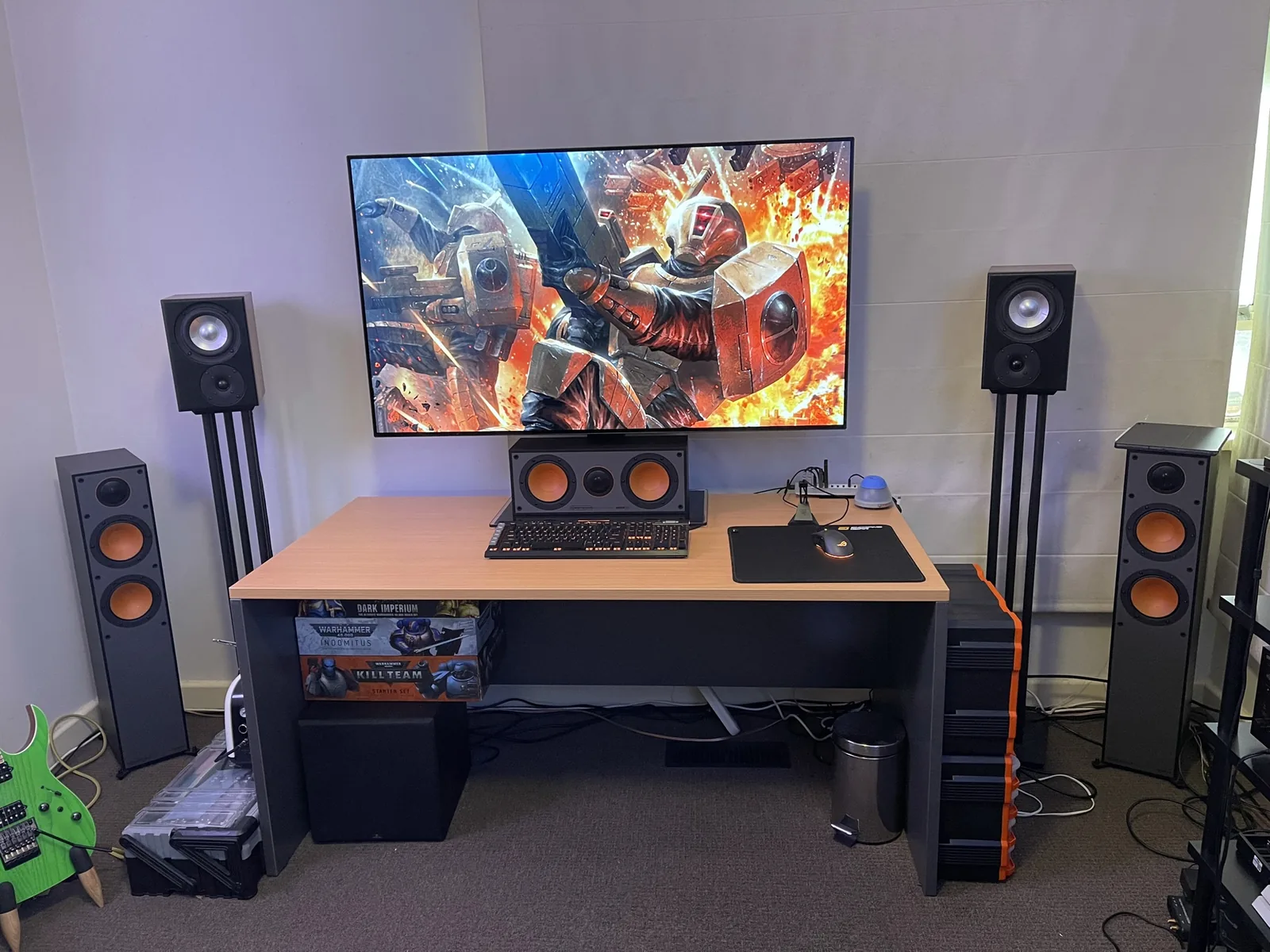 A desk flanked by bookshelf speakers, floorstanders and a subwoofer.
