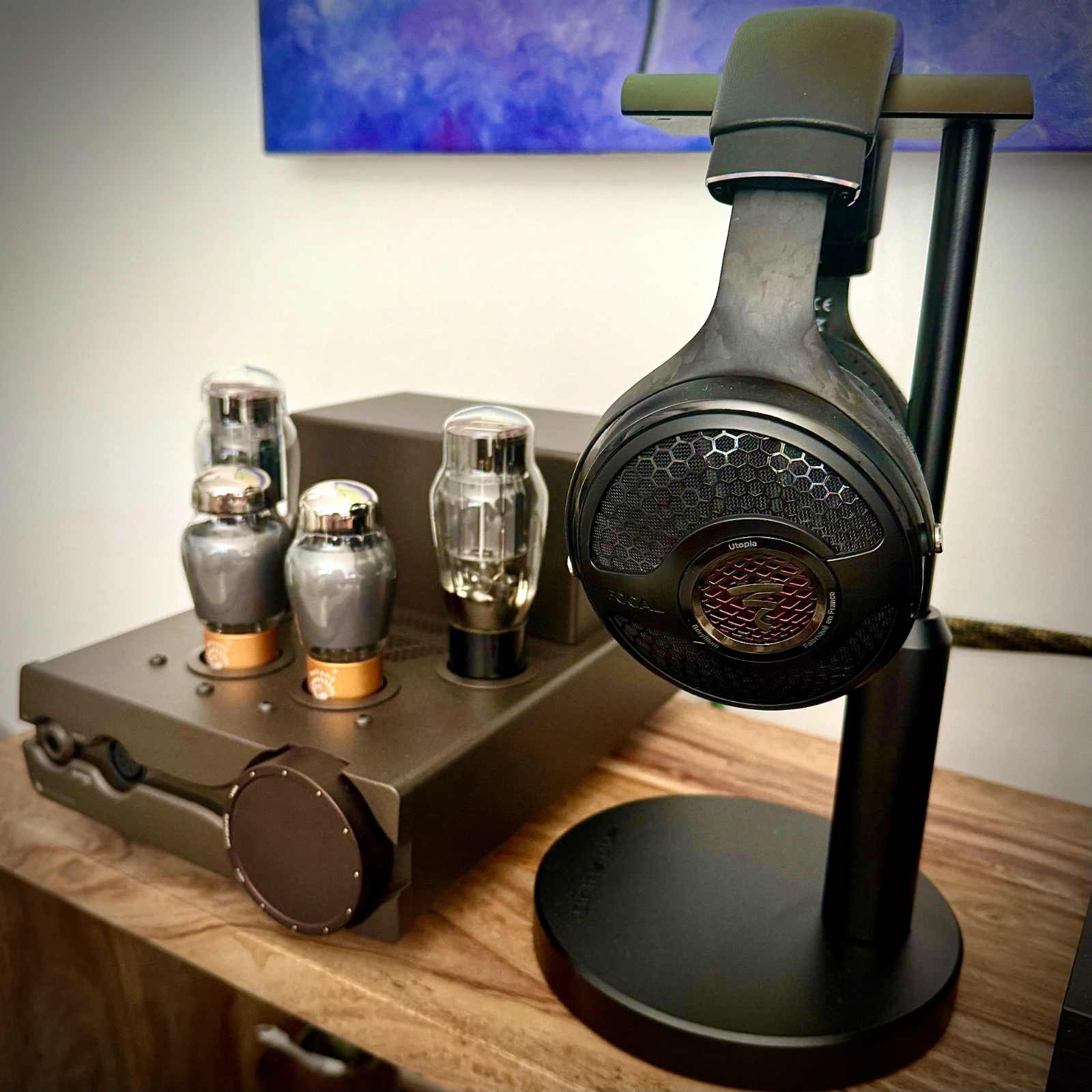 Focal Utopia on a headphone stand next to a Feliks Euforia Evo tube amplifier.